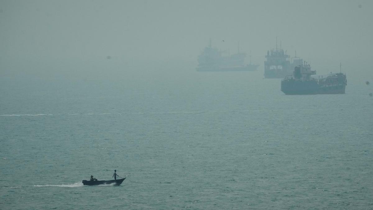 Navios e uma pequena embarcação no mar.